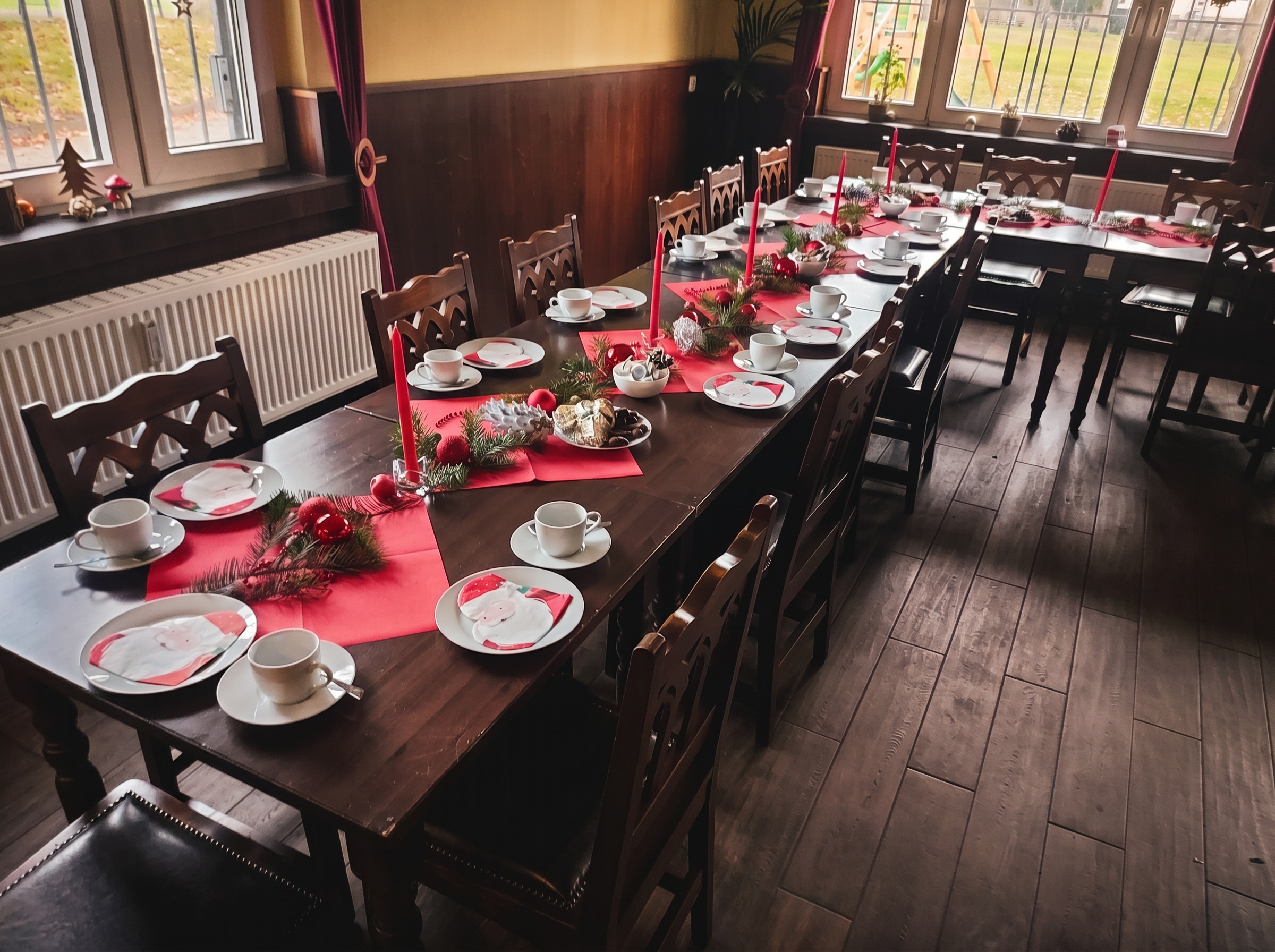 Weihnachtlich gedeckte Kaffeetafel mit roten Servietten und Tannenzweig
